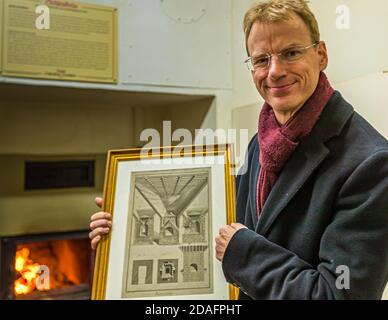 Matthias Trum aus Schlenkerla Bräu trocknete in der 6th. Generation der Familie vor dem Holzofen das grüne Malz. In der Hand hält er eine Zeichnung über die industrielle Malztrocknung nach Sir Nichola Halse. Die Engländer waren die ersten, die den Rauch von Bier verbannen. Um 1800 baute Georg Sedlmeyer von der Münchner Spatenbrauerei den ersten Nichtraucherofen in Deutschland. Heller Brauerei Schlenkerla Rauchbier Bamberg, Deutschland Stockfoto