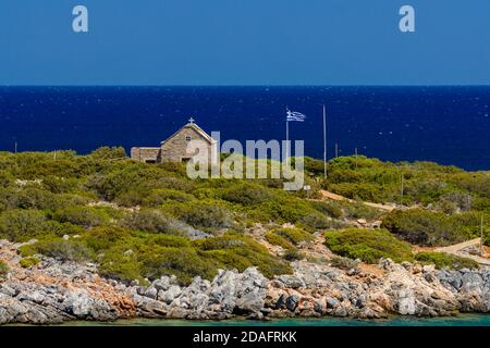 Kleine griechische Kirche neben dem kristallklaren Wasser Die Ägäis auf der Insel Kreta Stockfoto