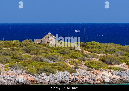 Kleine griechische Kirche neben dem kristallklaren Wasser Die Ägäis auf der Insel Kreta Stockfoto