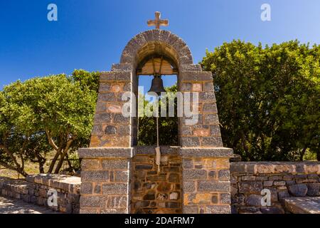 Außerhalb Glocke und Kreuz an einer kleinen, traditionellen griechischen Kirche auf der Insel Kreta Stockfoto