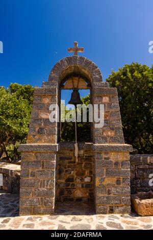 Außerhalb Glocke und Kreuz an einer kleinen, traditionellen griechischen Kirche auf der Insel Kreta Stockfoto