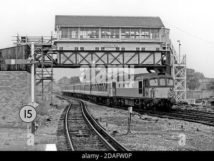 Ein Paar Diesellokomotiven der Klasse 33 mit den Nummern 33118 und 33109 oben und mit dem Tailing ein 6-REP-Elektrotriebwerk mit der Nummer 1901, das am 8. Juni 1991 unter der beeindruckenden obenliegenden Signalbox in Canterbury West fährt. Stockfoto