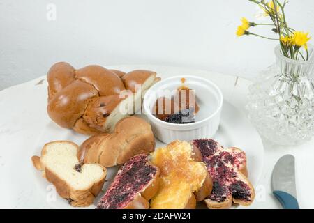 Traditionelles weihnachtsbrot aus der Slowakei. Weihnachts-Backwarenprodukt mit Butter und hausgemachter Marmelade serviert auf alten runden weißen Holztisch. Stockfoto