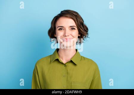 Foto-Porträt von niedlichen lächelnd hübsches Mädchen mit Brünette kurz Haare tragen grünes Hemd isoliert auf blauem Hintergrund Stockfoto