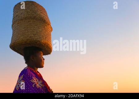 Frau mit Korb auf Kopf, Morondava, Madagaskar Stockfoto