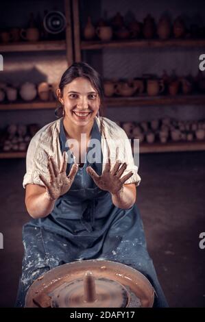 Stilvoller Keramik-Bildhauer arbeitet mit Ton auf einem Potter-Rad und am Tisch mit den Werkzeugen. Handarbeit. Stockfoto