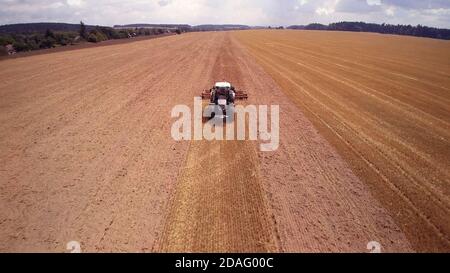 Drohne Luftaufnahme landwirtschaftlichen Traktor mit Pflügen. Pflügen der großen Felder. Stockfoto