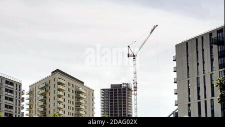 Wohnungen im Bau, Industriekran auf dem Gelände, neues Hochhaus. Stockfoto