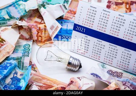 Faltiges russisches Geld, Glühbirne und Kalender, Lampe und Geld zerbröckelte Geld Stockfoto
