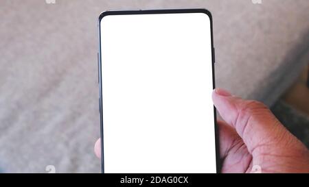 Nahaufnahme an der Hand mit modernem Mobiltelefon mit leerem weißen Bildschirm. Stockfoto