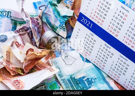 Faltiges russisches Geld, Glühbirne und Kalender, Lampe und Geld, zerknittertes Geld Stockfoto