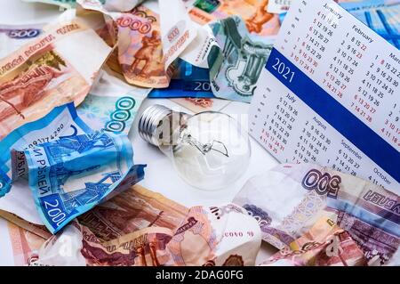 Faltiges russisches Geld, Glühbirne und Kalender, Lampe und Geld, zerknittertes Geld Stockfoto