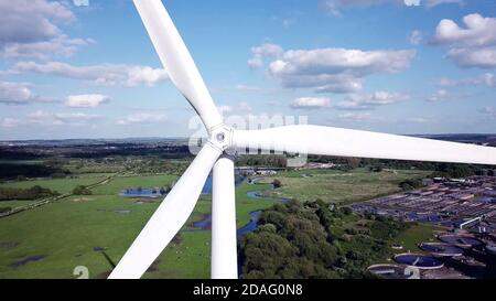 Nahaufnahme der Windturbine mit ländlichem Gebiet im Hintergrund. Stockfoto