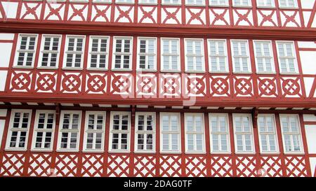 Rot-weiße, farbenfrohe Gebäudefassade mit Fenstern. Alte deutsche europäische Architektur. Stockfoto