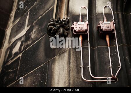 Notausschalter an der Seite des alten Steingebäudes. Stockfoto