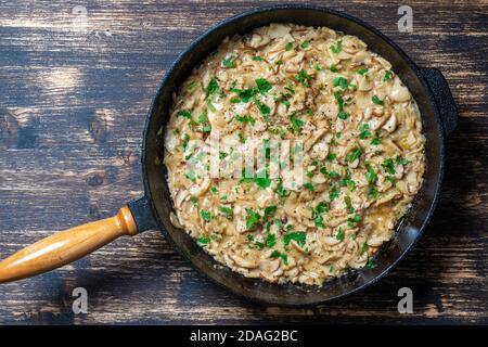Geröstete Wildpilze auf der Pfanne. Gebraten von Steinpilzen in der Pfanne auf einem hölzernen Hintergrund, Nahaufnahme. Ukraine Stockfoto