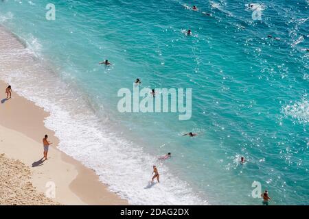 Blick auf den türkisfarbenen Strand. Schöner Kaputas Strand (Türkei) mit Menschen, die unter der Sonne und im Meer ruhen Stockfoto