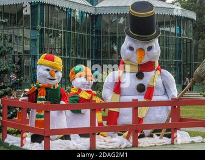 Petropolis, Brasilien - 23. Dezember 2008: Weihnachten im grünen Park: Nahaufnahme von drei Schneemännern mit Hüten und Schals vor dem Gewächshaus. Stockfoto