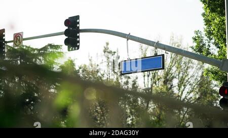 Stadtampel mit leerem blauen Straßenschild. Stockfoto