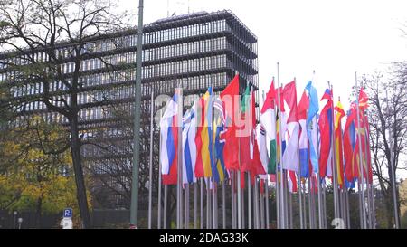 Schwenkende europäische vertikale Flaggen neben einem modernen Regierungsgebäude. Stockfoto