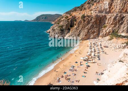 Blick auf den türkisfarbenen Strand. Schöner Kaputas Strand (Türkei) mit Menschen, die unter der Sonne und im Meer ruhen Stockfoto