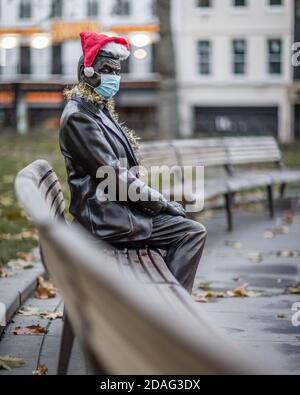 Ein trauriger und einsamer Herr Bean, der eine Maske und einen weihnachtshut trägt, veranschaulicht die Zeiten, in denen wir leben. Stockfoto