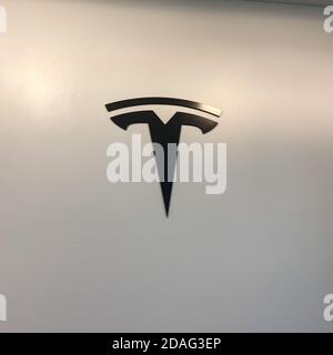 Orlando, FL/USA-2/17/20: Das Tesla-Logo an der Wand in einem Tesla-Einzelhandelsgeschäft. Tesla ist ein Elektroautomobilunternehmen im Besitz von Elon Musk. Stockfoto