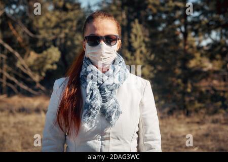 Schutz vor Krankheiten und Coronavirus, trägt die Frau eine medizinische Maske und Sonnenbrille. Frühjahrsmode 2020 Stockfoto