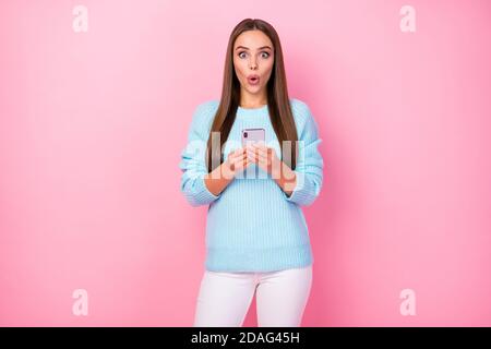 Foto von ziemlich schockiert Dame halten Telefoncheck Anhänger genießen Viele repost wie Kommentare tragen gestrickten blauen Pullover weiße Hose Isoliertes Pastell Stockfoto