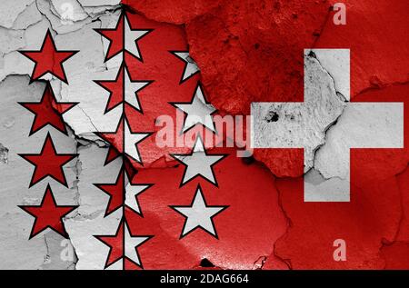 Flaggen des Kantons Wallis und der Schweiz auf rissige Wand gemalt Stockfoto