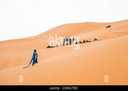 Merzouga, Marokko - APRIL 29 2019: marokkanischer Spaziergang in der Wüste bei den Kamelen, in der Sahara Stockfoto