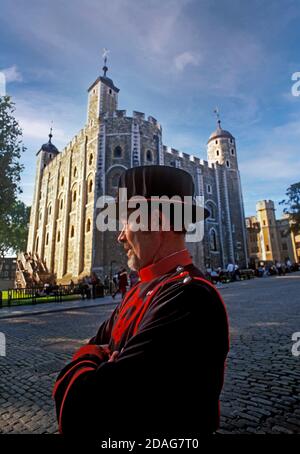 Yeoman Warder (Beefeater) Im Dienst am Tower of London mit den Weißen Turm hinter City of London UK Stockfoto