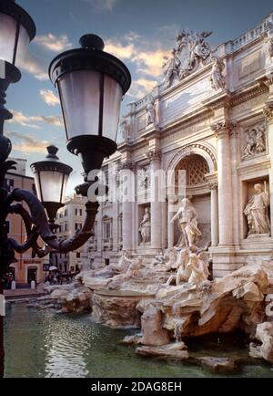 ROM Trevibrunnen mit Statuen und Wasserfällen mit traditioneller Straße Laternen im Vordergrund bei Sonnenuntergang Rom Italien Stockfoto