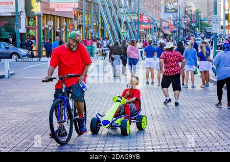 Ein Vater und ein Sohn ruhen sich aus, während sie ihre Fahrräder in der Beale Street, 12. September 2015, in Memphis, Tennessee, fahren. Stockfoto