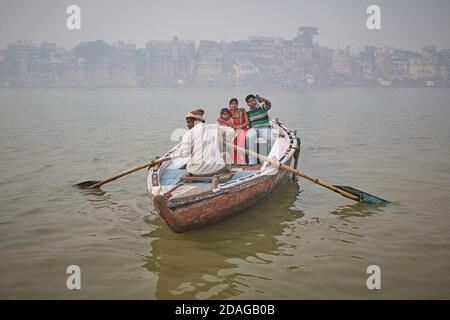 Varanasi, Indien, Januar 2016. Eine Familie in einem Boot im Nebel segelt auf dem Ganges Fluss. Stockfoto