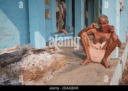 Varanasi, Indien, Januar 2016. Ein Mann fixiert seine Augenbrauen in einem Ghat am Ganges. Stockfoto