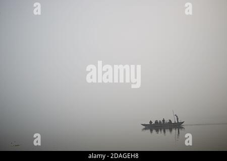 Varanasi, Indien, Januar 2016. Ein Boot im Nebel, das auf dem Ganges-Fluss segelt. Stockfoto