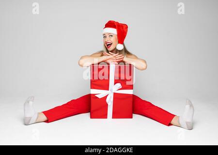 Lustige Frau sitzt mit einer großen roten Box Stockfoto