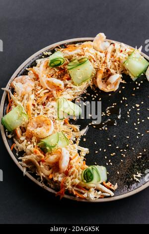 Asiatischer Gemüsesalat mit Garnelen auf schwarzem Hintergrund Stockfoto