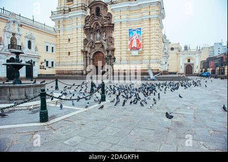 Tauben gehen in die Luft vor der Kirche und dem Kloster San Francisco (Basílica y Convento de San Francisco) aus dem 17. Jahrhundert, Lima, Peru. Stockfoto