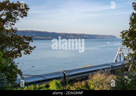 Amtrak-Zug, der mit ein paar Booten am Hudson River entlang fährt Auf dem Wasser Stockfoto