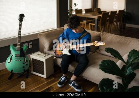 Junge Teenager-Musiker spielen elektrische Gitarre zu Hause Stockfoto