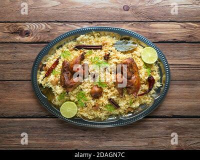 Chicken Mandi mit Datteln auf einem Holztisch. Arabische Küche. Draufsicht. Stockfoto