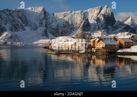 Das Licht des Wintermorgens leuchtet auf gelben Rorbu-Hütten in Sakrisøy, Moskenesøy, Lofoten Islands, Norwegen Stockfoto