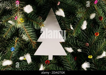 Layout aus Christbaumzweigen mit bunten Knöpfen und Schaumschnee. Nature New Year Konzept. Stockfoto