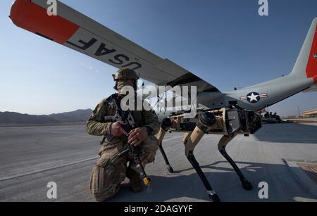 US Air Force Tech. Sgt. Johnny Rodriguez hält Sicherheit auf der Fluglinie neben dem Ghost Q-UGV unbemannten Bodenfahrzeug bekannt als der Roboter Hund, während einer Advanced Battle Management System Übung auf Nellis Air Force Base 1. September 2020 in Las Vegas, Nevada. Stockfoto