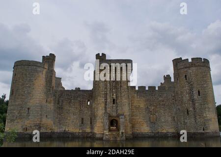 Blick über den Graben (See) auf die Torhosue einer ruinierten englischen mittelalterlichen Burg (Bodiam Castle, UK) Stockfoto