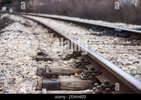 Holzschläfer auf einer alten Eisenbahnstrecke mit weißem Schotter in einer Kurve, auf einer Linie für Fracht- und Personenverkehr. Bild Stockfoto