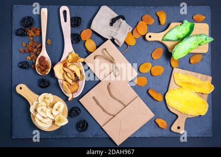 Verschiedene getrocknete Früchte in Öko-Paket. Konzept der Öko-Pakete von Wertstoffen. Getrocknete Aprikosen, Rosinen, Mango, Papaya, Pflaumen, Banane. Stockfoto