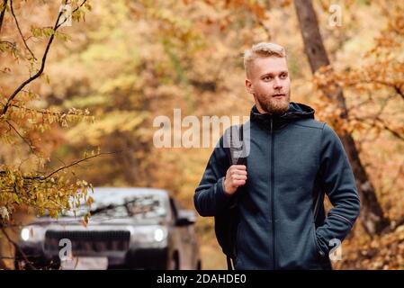 Erfolgreicher Geschäftsreisender auf dem Hintergrund des Autos in Der Herbstwald Stockfoto